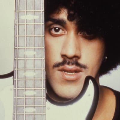 Phil Lynott lähikuvassa bassokitaran takana.