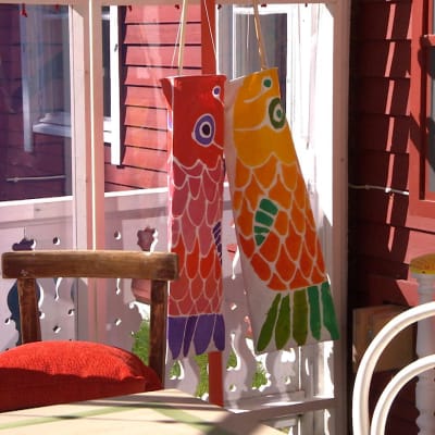 Vindsockor med karpfisk motiv hänger på en veranda.