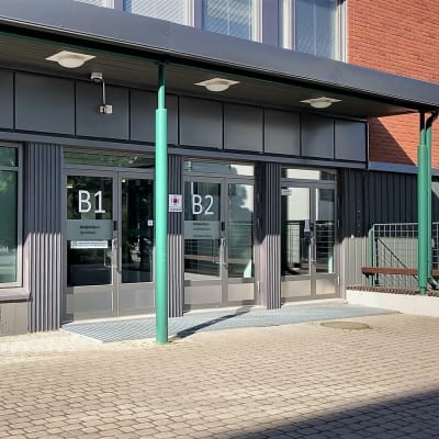 Liiketila, jonka ovissa kirjaimet B1 ja B2 sekä kyltti, jossa kerrotaan, että talossa toimii Oulun kärjaoikedun Ylivieskan kanslia ja käräjäsali.