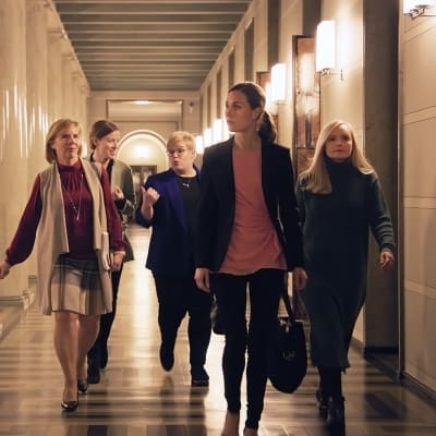 Anna-Maja Henriksson, Li Andersson, Annika Saarikko, Sanna Marin och Maria Ohisalo går tillsammans i riksdagens korridor.