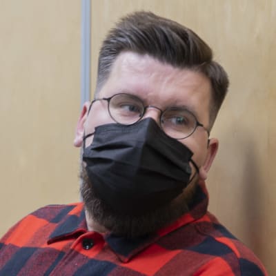 Sebastian Tynkkynen odottaa oikeudenkäyntiä maski naamallaan