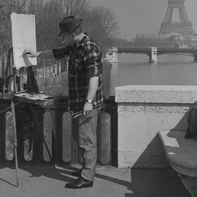 Maalari Seinen rannalla Pariisissa, taustalla Eiffelin torni.