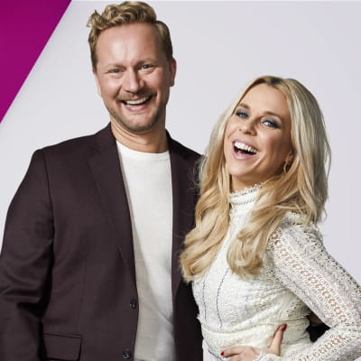 UMK:n juontajat Krista Siegfrids ja Mikko Silvennoinen hymyilevät leveästi purppuraa ja harmaata yhdistelevän taustagrafiikan edessä. Kuvassa myös teksti UMK, Uuden Musiikin Kilpailu.