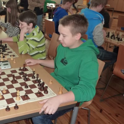 skolelever spelar schack