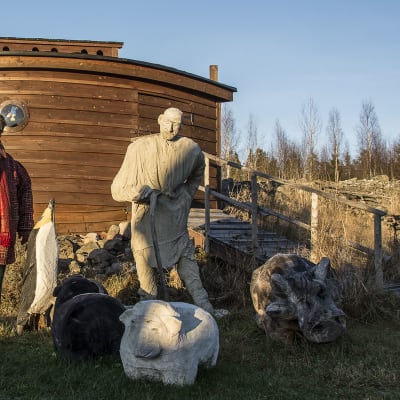 Kuvassa puinen Nooan arkki, Nooa-patsas ja Leena Harjunpää