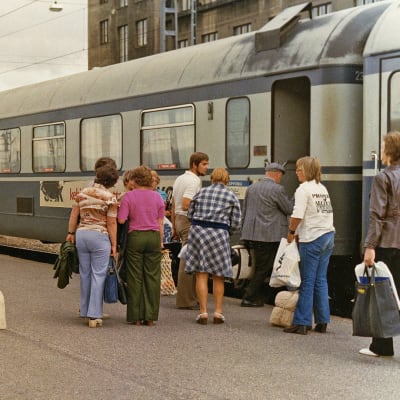 Kuvassa matkustajat nousevat junaan asemalaiturilla Helsingissä 1976