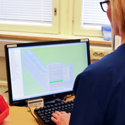 Sairaanhoitaja katsoo tietokoneen ruutua.