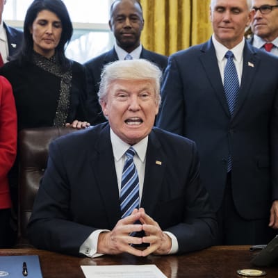 Donald Trump lähipiirinsä ympäröimänä Valkoisessa talossa maanantaina 13. maaliskuuta.