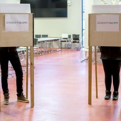 Ihmisiä äänestämässä äänestyskopissa.