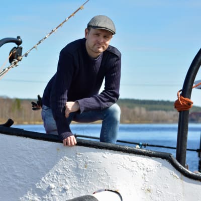 Mies seisoo höyrlaivan keulassa telakalla.