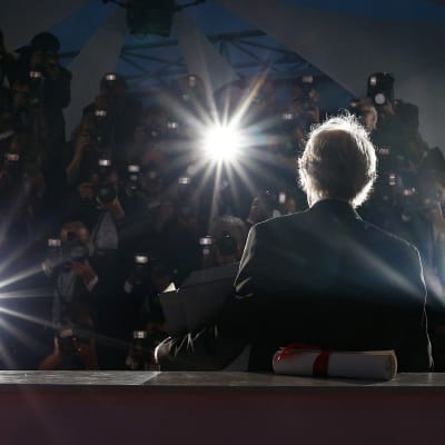 Kultaisella palmulla palkittu englantilaisohjaaja Ken Loach kuvattuna lehdistön ympäröimänä Cannesissa 22. toukokuuta 2016.