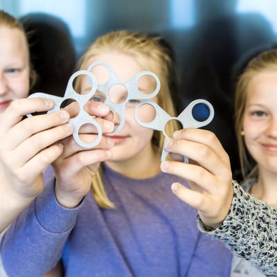 Tytöt pitävät käsissään itse 3D-tulostettuja fidget spinnereitä