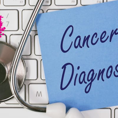 ett stetoskop och en postit lapp med texten cancer diagnosis och båda är på en keyboard