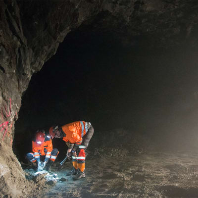 Kaivosmiehet tutkivat malmia tunnelissa.