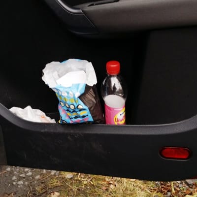 Limsapullo ja irtokarkkipussi auton ovikotelossa