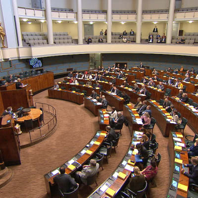 Plenisalen i riksdagshuset i Helsingfors, med ett stort antal ledamöter på plats. 