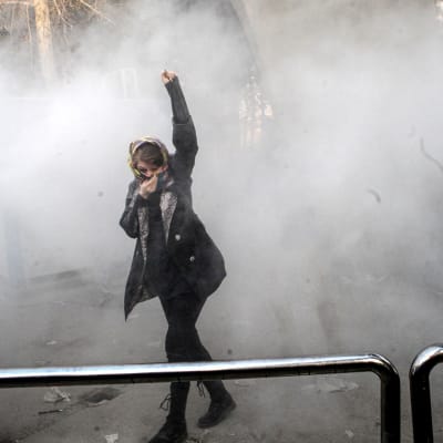 Iranilaisopiskelija yrittää suojautua kyynelkaasulta mielenosoituksessa
