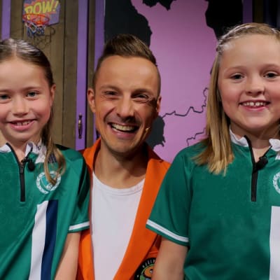 Superhjälparnas programledare Jontti Granbacka poserar tillsammans med två flickor som besöker tv-studion