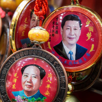 Matkamuistoja Xi Jinpingin ja Mao Zedongin kuvilla myynnissä Pekingissä.