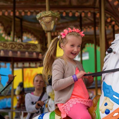 Lapsi matkustaa karusellissa hevosella