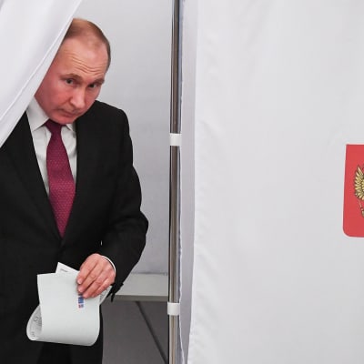 Presidentti Vladimir Putin tulee ulos äänestyskopista.