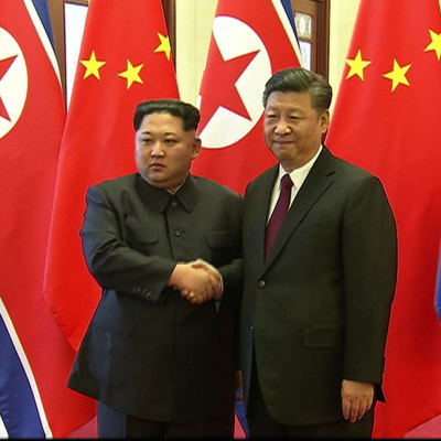 Ett handslag mellan Nordkoreas ledare Kim Jong-Un och Kinas president Xi Jinping inför kinesisk tv i Peking på tisdagen den 27.3.