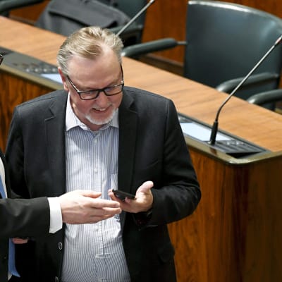 Pääministeri Juha Sipilä ja kansanedustaja  Antero Laukkanen (kd.) tutkivat kännykkää eduskunnan täysistunnossa.