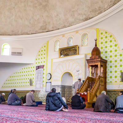 miehet istuvat moskeijan lattialla