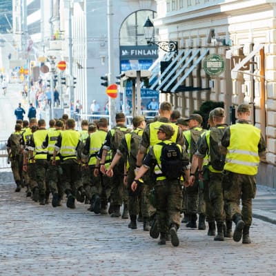 Sotilaspoliisit kävelevät presidentinlinnan läheisyydessä Helsingissä.