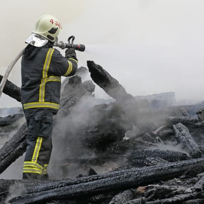 Palomies sammuttaa Kiihtelysvaaran kirkon paloa.