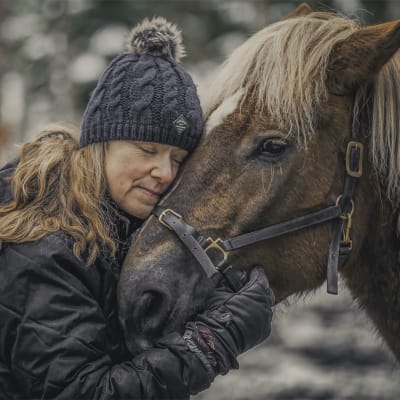Nainen halaa hevosta