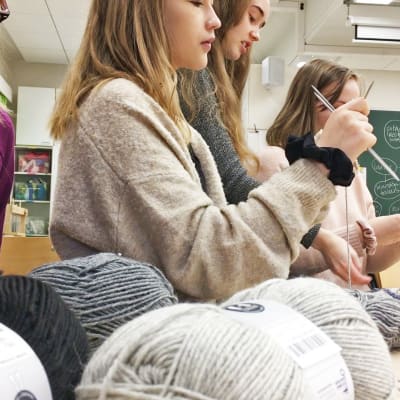 Yhdeksännen luokan tytöt neulomassa sukkia.