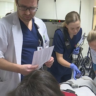 Päivystyksen ovella Kanta-Hämeen keskussairaalassa Markku Grönroos ja hoitotiimi tutkivat aivoinfarktipotilasta