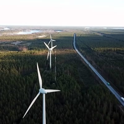 Tre vindmöllor vid en väg.