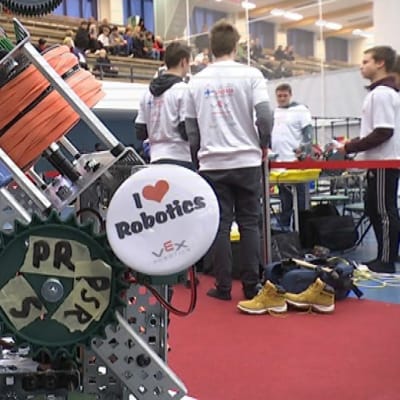 Robotiikan SM-kisoissa etualalla robotti, taustalla kilpailijoita ja yleisöä 