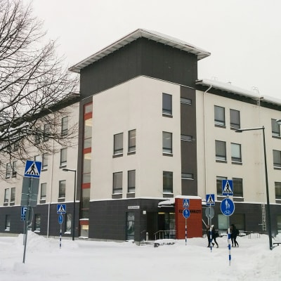 Vaalea, nelikerroksinen Mehiläisen hoivakotikiinteistö kaupunkimaisemassa Kuusankoskella talvella.