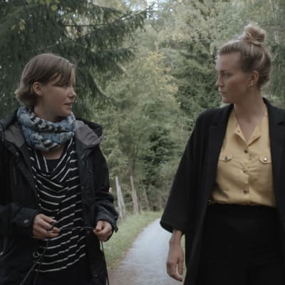 Maria Holmberg och Märta Westerlund promenerar på en skogsväg i Pargas.