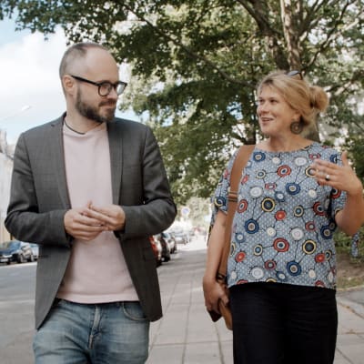 en man och en kvinna som går på gatan och pratar med varandra
