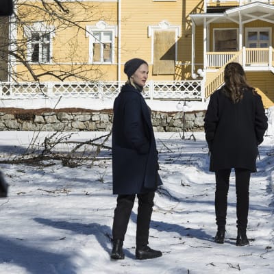 Näyttelijät televisiosarjan kuvauksissa vanhan kartanon lumisella pihalla.