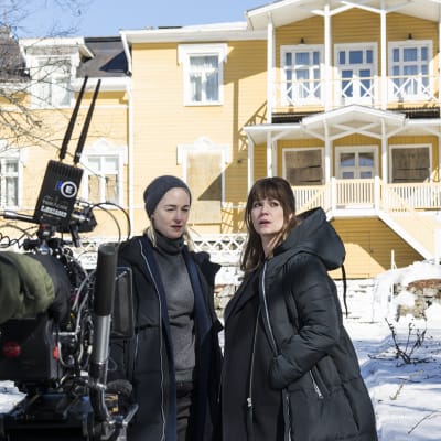 Näyttelijät Sofia Pekkari ja Pihla Viitala televisiosarjan kuvauksissa vanhan kartanon lumisella pihalla.