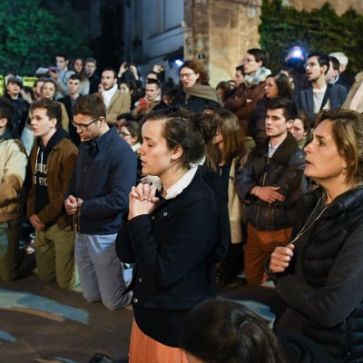 Ihmiset rukoilivat jalkakäytävällä Notre Damen lähistöllä 15. huhtikuuta. 