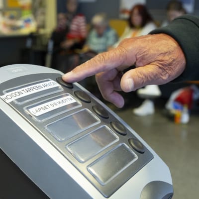 Ett finger rör könummerapparat i Kvarnbäckens hälsostation.