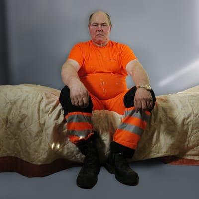 Ari istuu sängyllä.