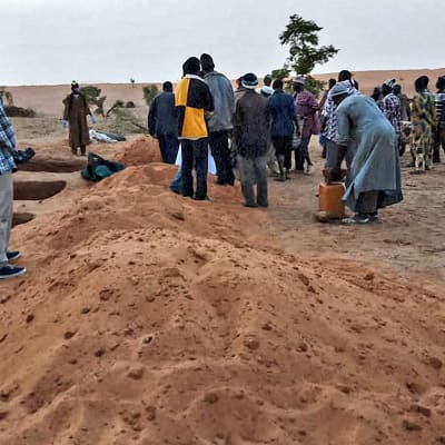 Dogon-heimon jäsenet sekä viranomaiset seisovat lähellä hautoja Sobane Dan kylässä Malissa 11. kesäkuuta.