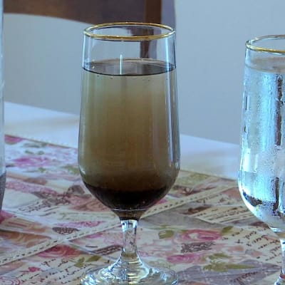 Två glas med svart och klart vatten.