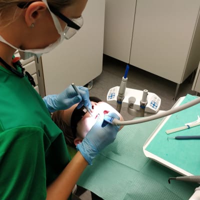Suuhygienisti tutkii potilaan suuta