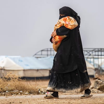 Nainen kantoi lasta al-Holin leirillä 9. joulukuuta.