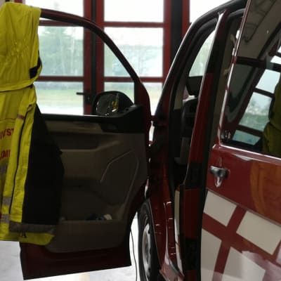 Päivystävän palomestarin takki roikkuu paloauton ovessa.