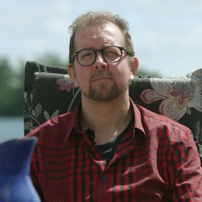 Henrik Kniberg sitter i en stol vid vattnet.