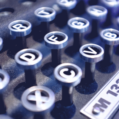 Kuvassa on lähikuva Enigma- koodisalauslaitteen M1322 näppäimistöstä. Näppäimistöstä katoaa satunnaisesti merkkejä.